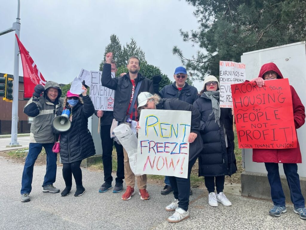 BC ACORN Group shot in Surrey, BC. Sign reads "Rent Freeze NOW!"