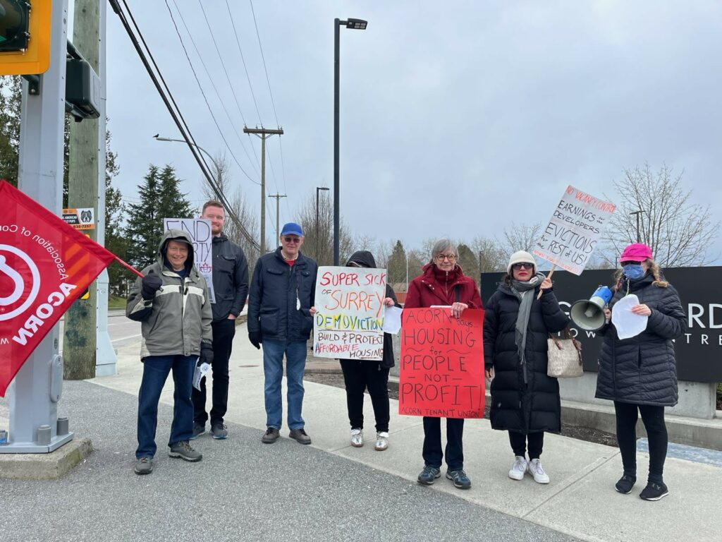 BC ACORN members rallying. Signs read: "Super sick of Surrey demoviction \ build & protect affordable housing" and "ACORN Housing for people not profit" and "No vacancy control means earnings for developers and evictions for the rest of us"