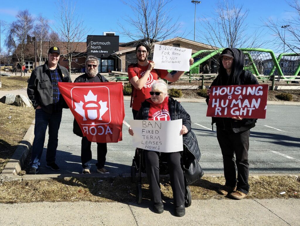 Nova Scotia Halifax ACORN group photo national day of action. Signs read:
"ban fixed term leases now" "$1200 and up for rent is not affordable" and "housing is a human right"